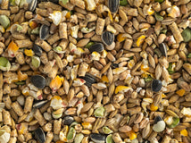 A close-up view of chicken feed which includes a mix of grains, seeds, and pellets.